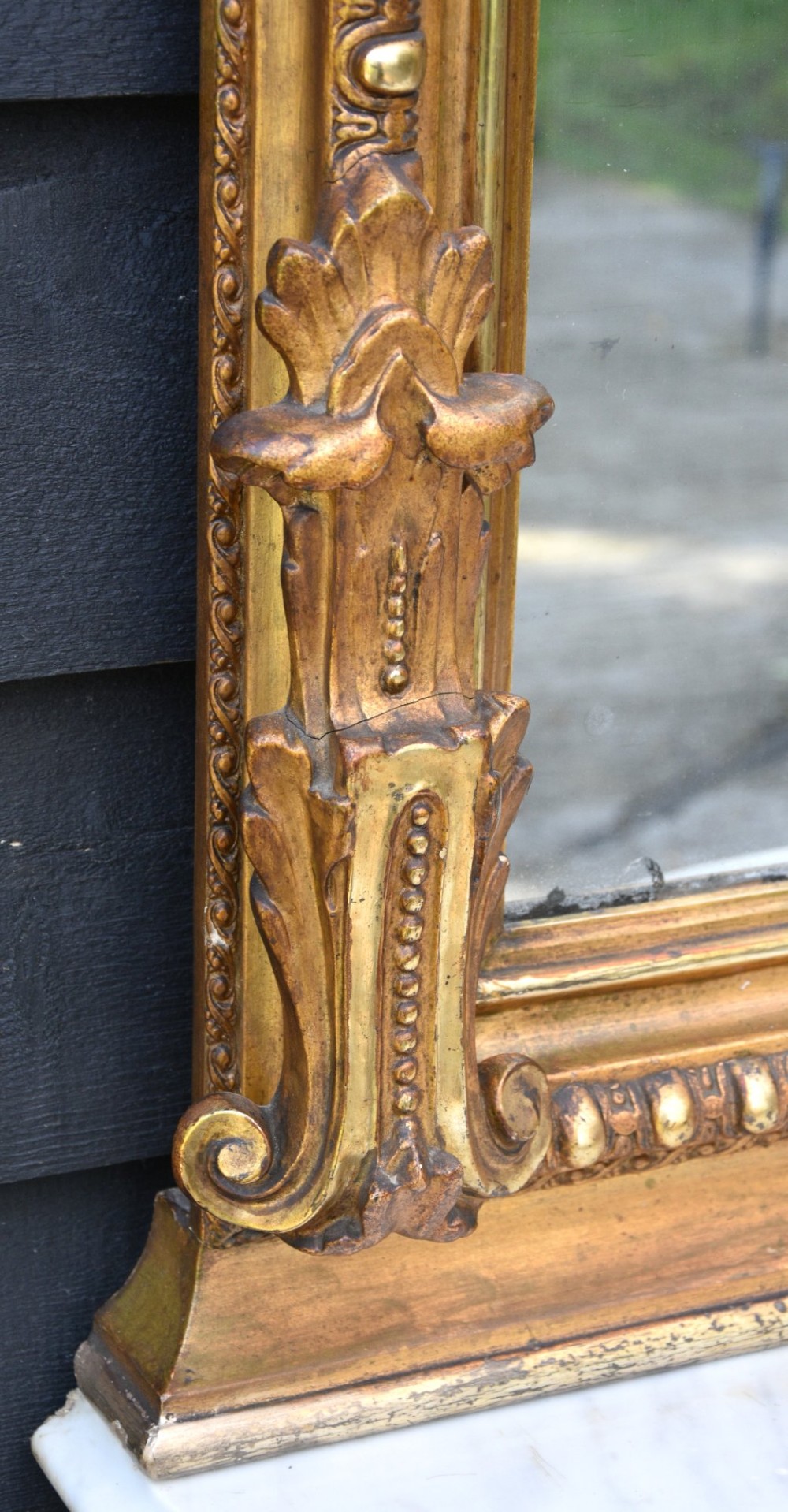 A French giltwood pier mirror featuring a carved rocaille cresting, mounted above a matching marble-topped console table with cabriole legs. View VI