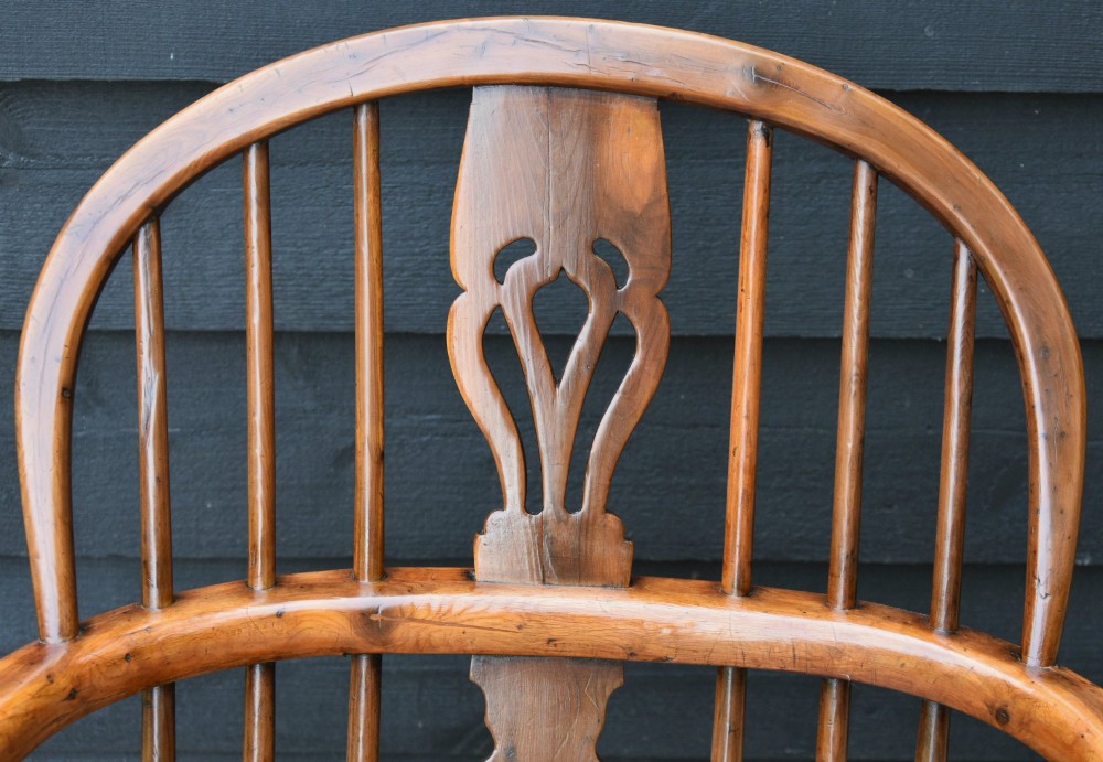 A 19th-century English Windsor armchair made from yew and elm wood featuring a hoop back, a central pierced splat, turned legs, and a crinoline stretcher. View II