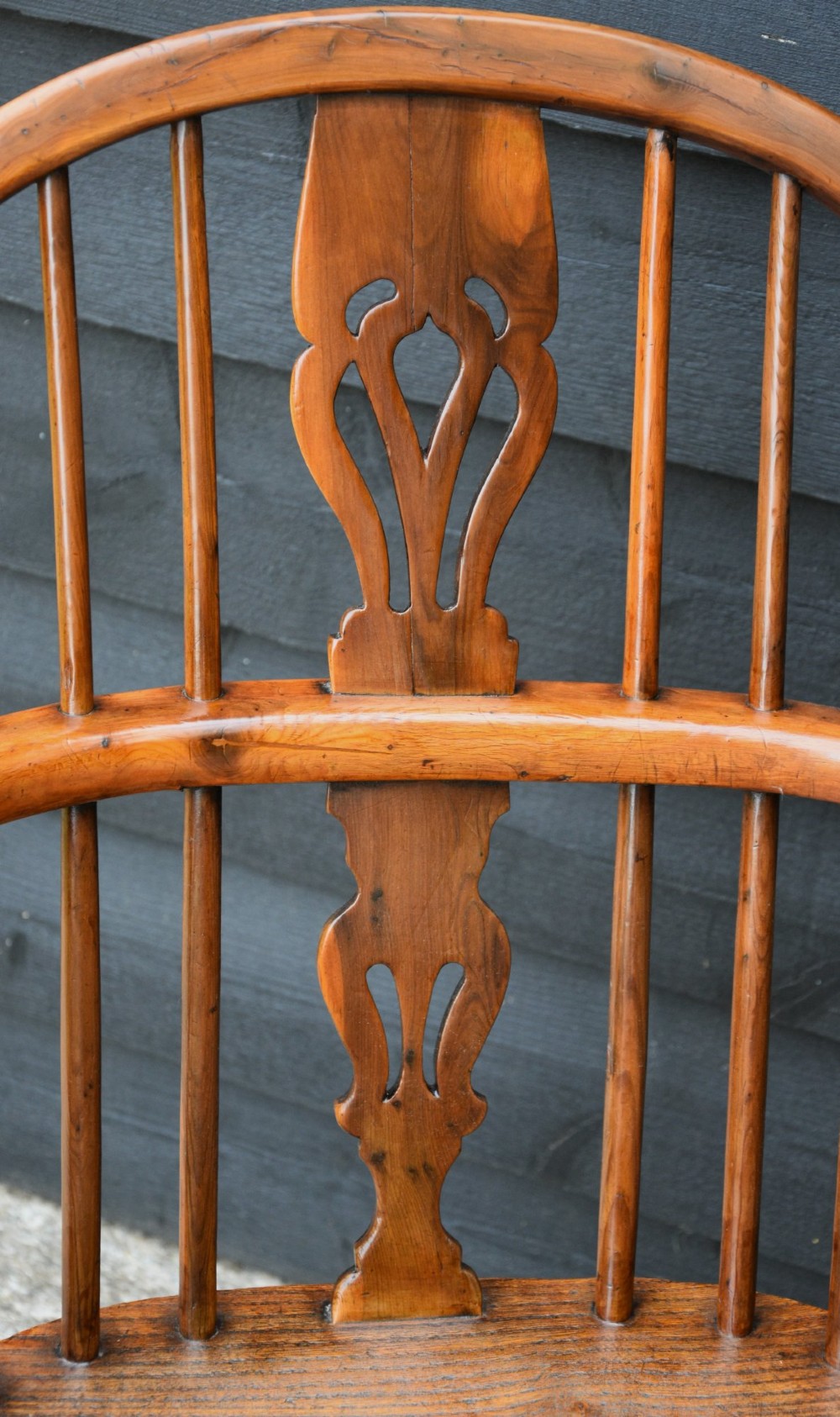 A 19th-century English Windsor armchair made from yew and elm wood featuring a hoop back, a central pierced splat, turned legs, and a crinoline stretcher. View VII