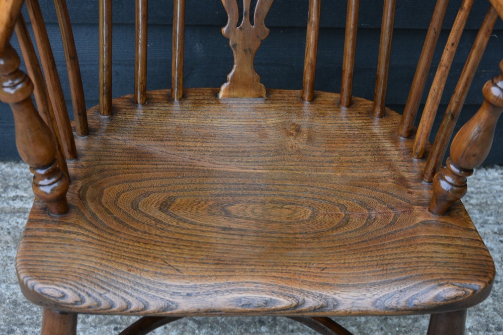 A 19th-century English Windsor armchair made from yew and elm wood featuring a hoop back, a central pierced splat, turned legs, and a crinoline stretcher. View VIII
