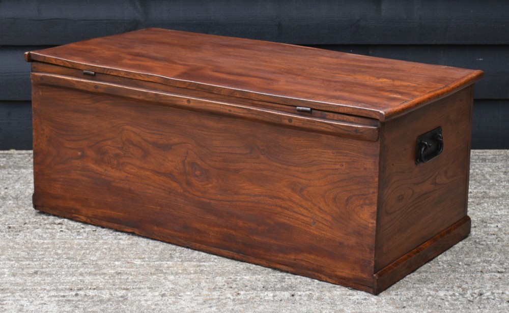 A rectangular Georgian elm blanket box featuring a hinged top lid, front keyhole, side iron handles, and a simple plinth base. View V
