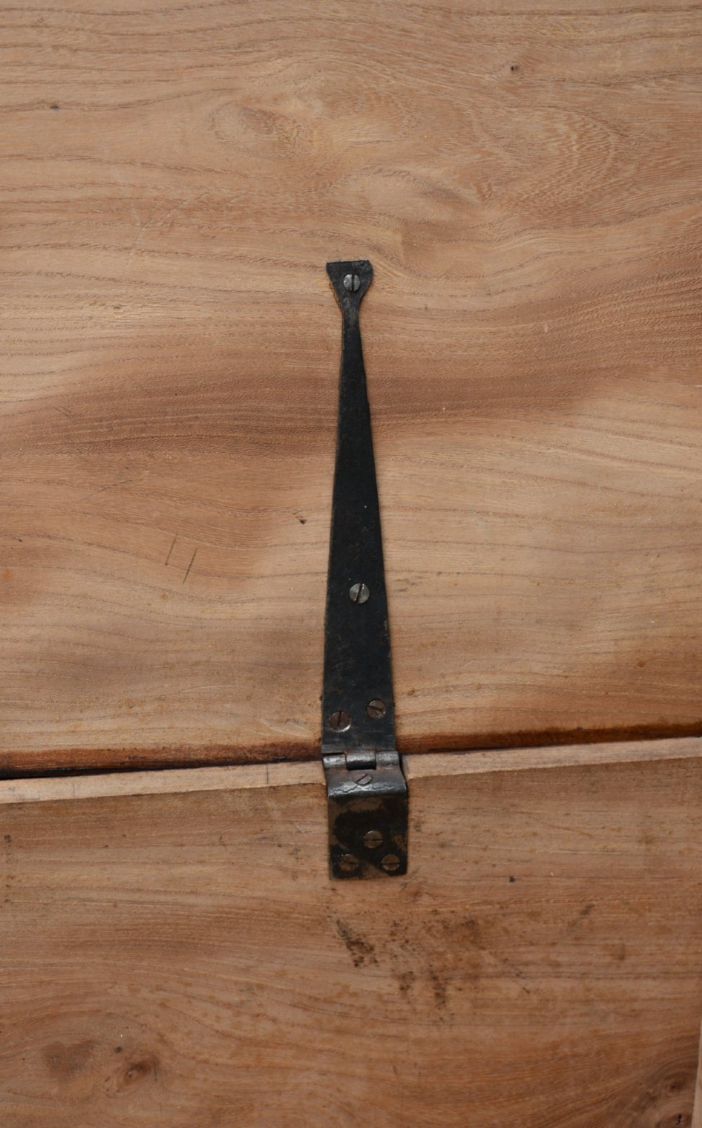 A rectangular Georgian elm blanket box featuring a hinged top lid, front keyhole, side iron handles, and a simple plinth base. View VII