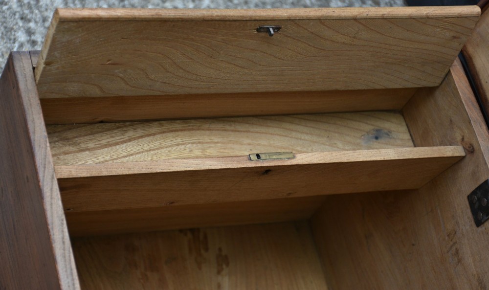 A rectangular Georgian elm blanket box featuring a hinged top lid, front keyhole, side iron handles, and a simple plinth base. View VIII