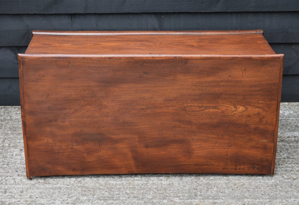 A rectangular Georgian elm blanket box featuring a hinged top lid, front keyhole, side iron handles, and a simple plinth base. View X