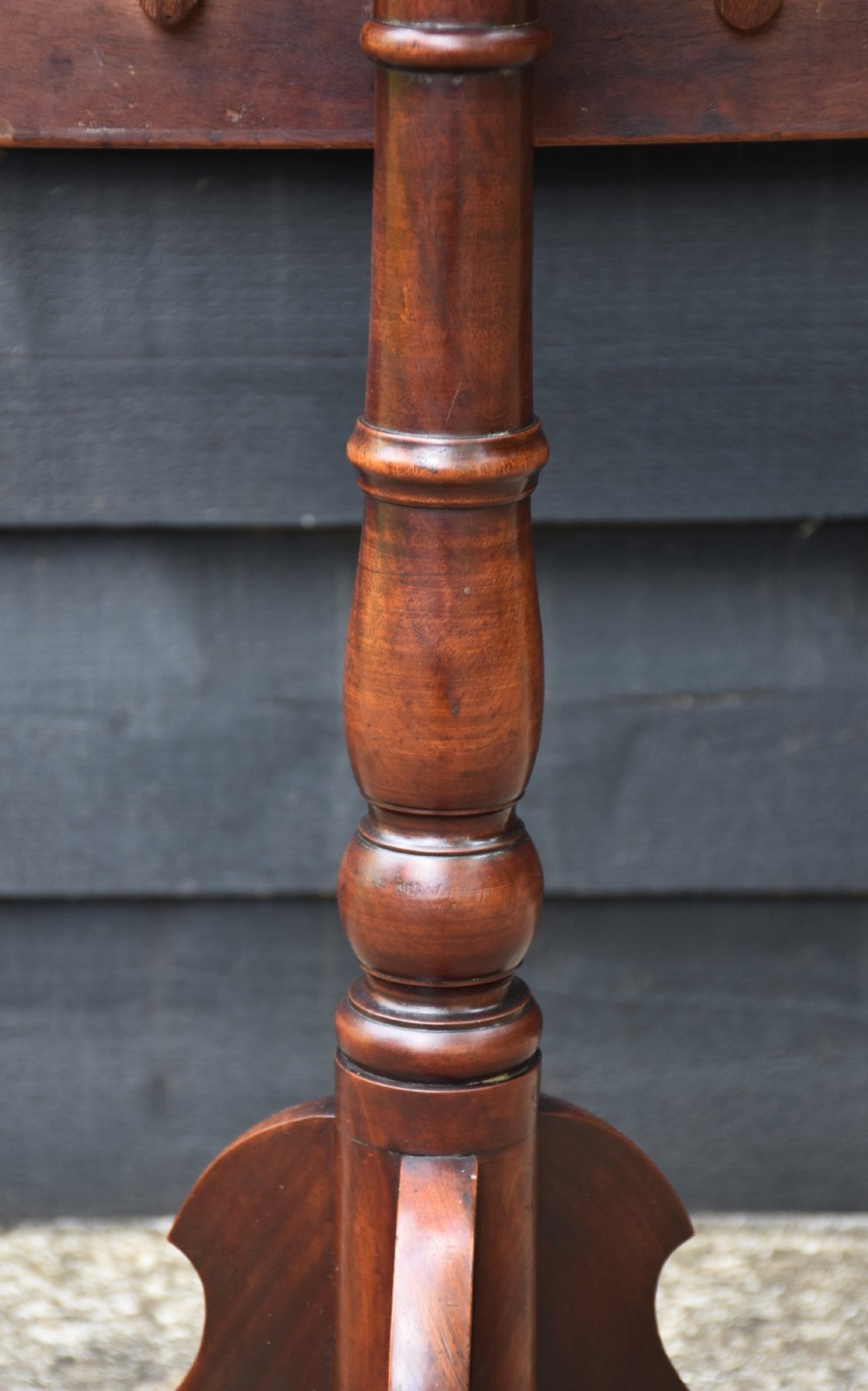 A 19th-century mahogany tilt-top wine table with a rectangular rounded surface, turned pedestal column, and three splayed legs. View V