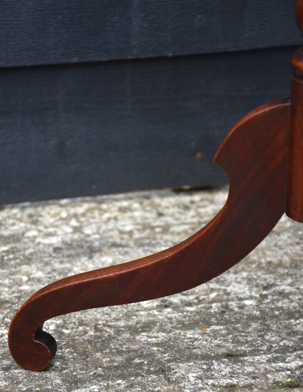 A 19th-century mahogany tilt-top wine table with a rectangular rounded surface, turned pedestal column, and three splayed legs. View VI
