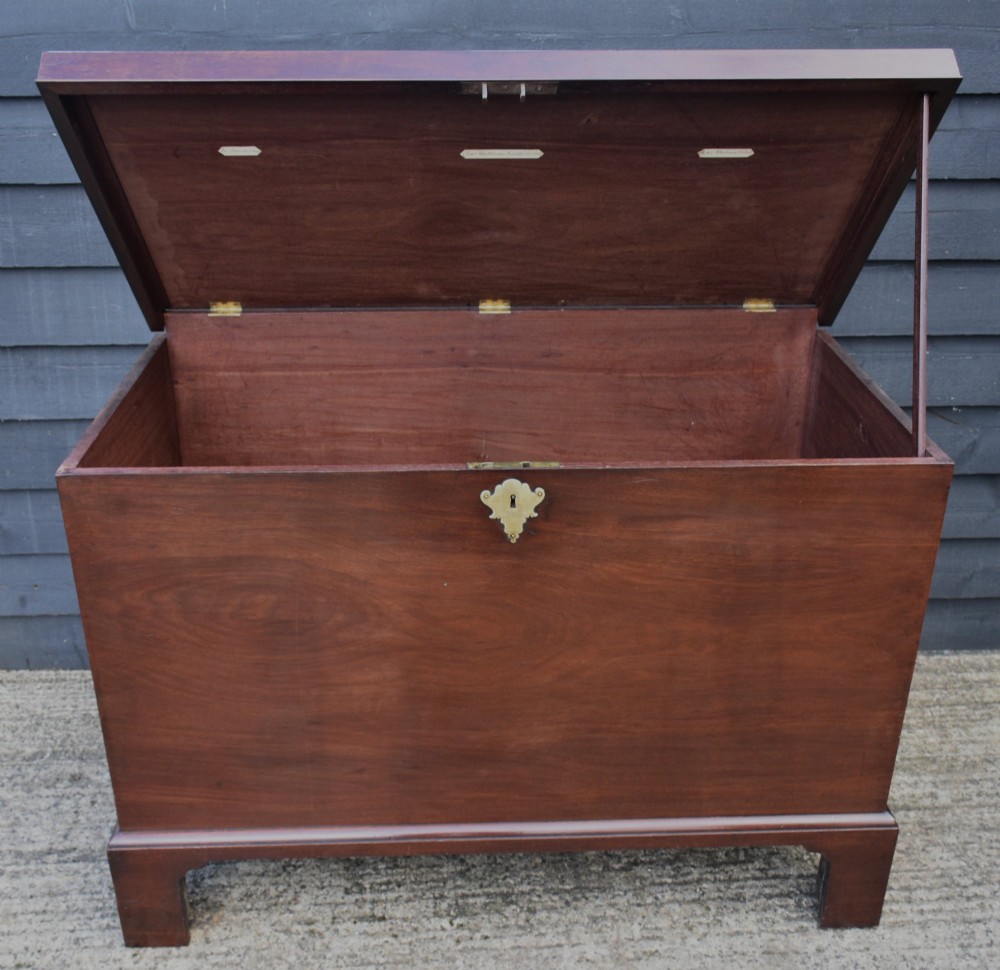 A Georgian mahogany travelling chest featuring side brass carrying handles, an escutcheon lock, and raised bracket feet. View III