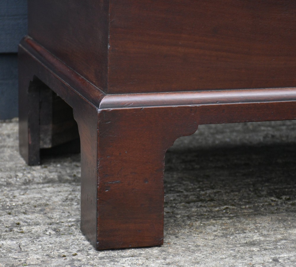 A Georgian mahogany travelling chest featuring side brass carrying handles, an escutcheon lock, and raised bracket feet. View IV