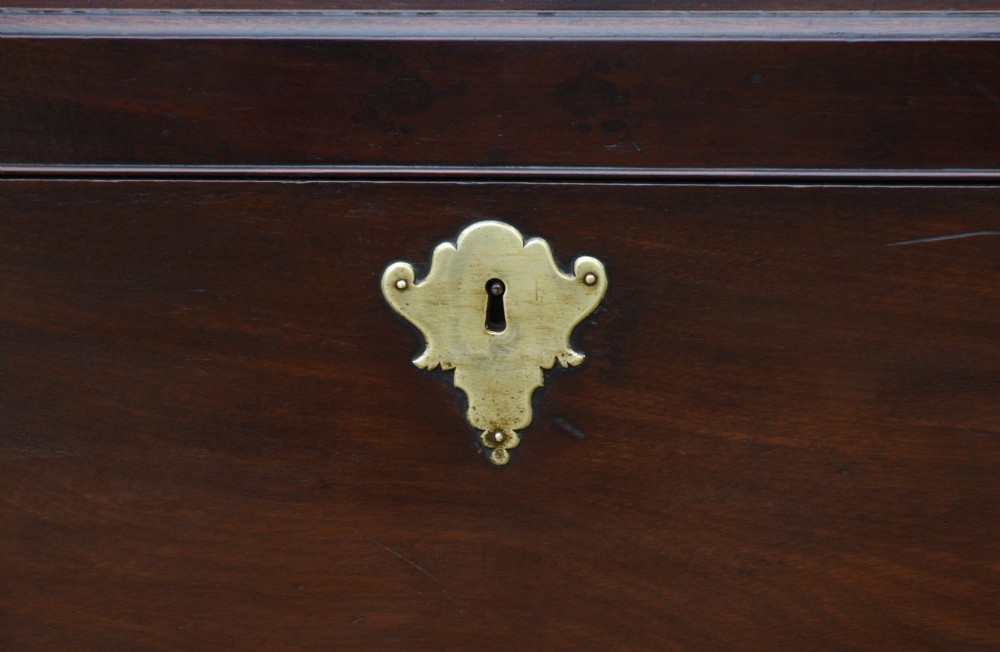 A Georgian mahogany travelling chest featuring side brass carrying handles, an escutcheon lock, and raised bracket feet. View VII
