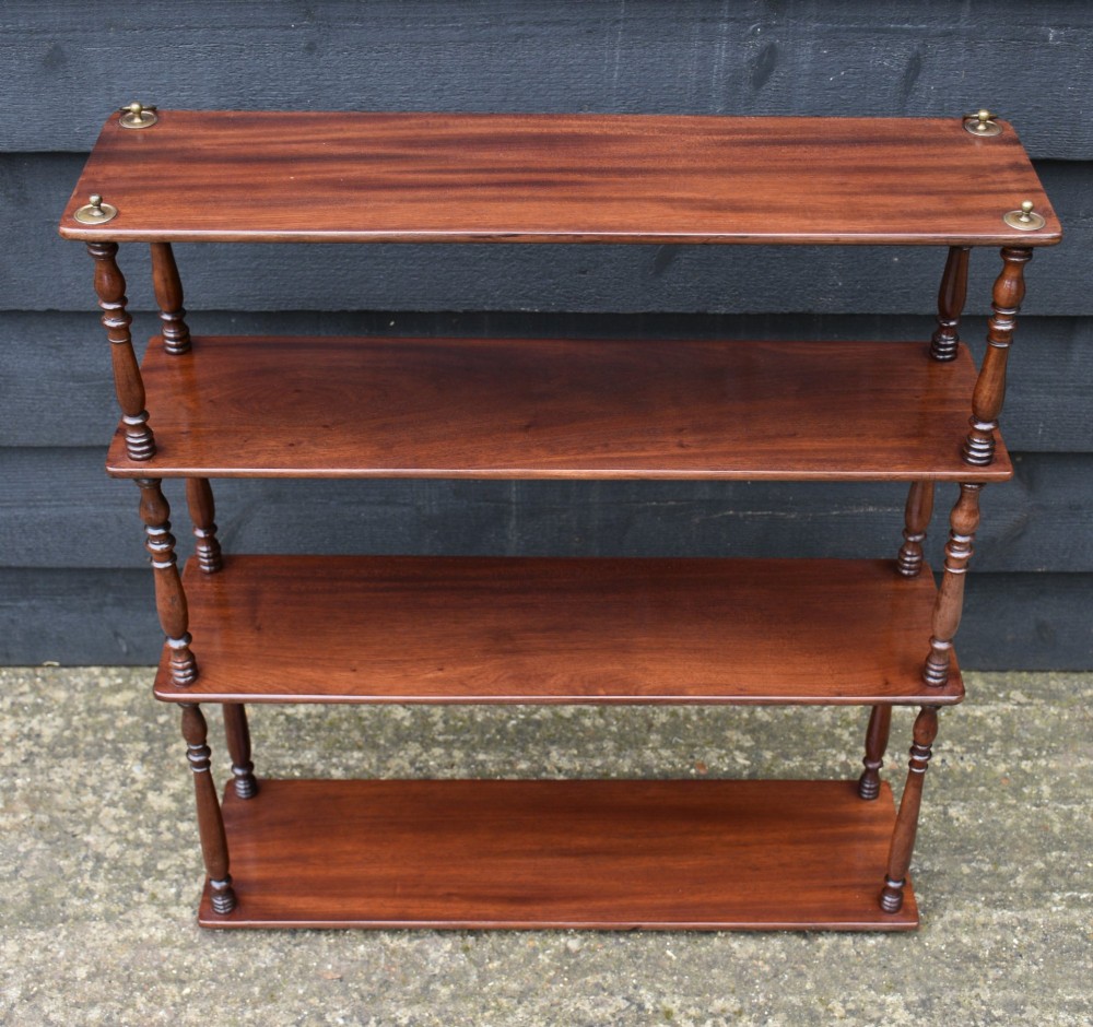 A four-tier Victorian mahogany hanging wall shelf unit featuring slim open shelves supported by slender turned spindles with brass mounting rings at the top. View IV