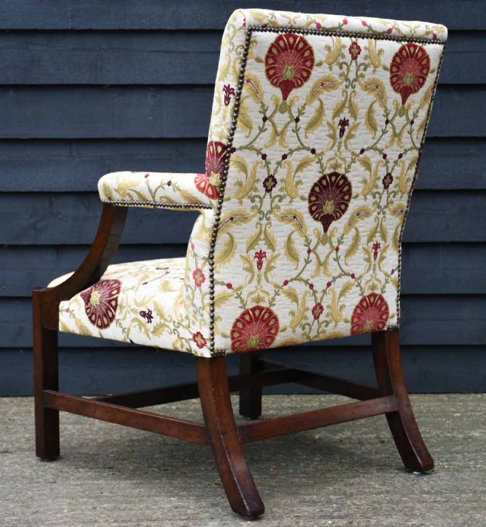 A Georgian Gainsborough armchair featuring a dark mahogany frame with curved arm supports, upholstered in cream fabric with red and green botanical patterns. View III