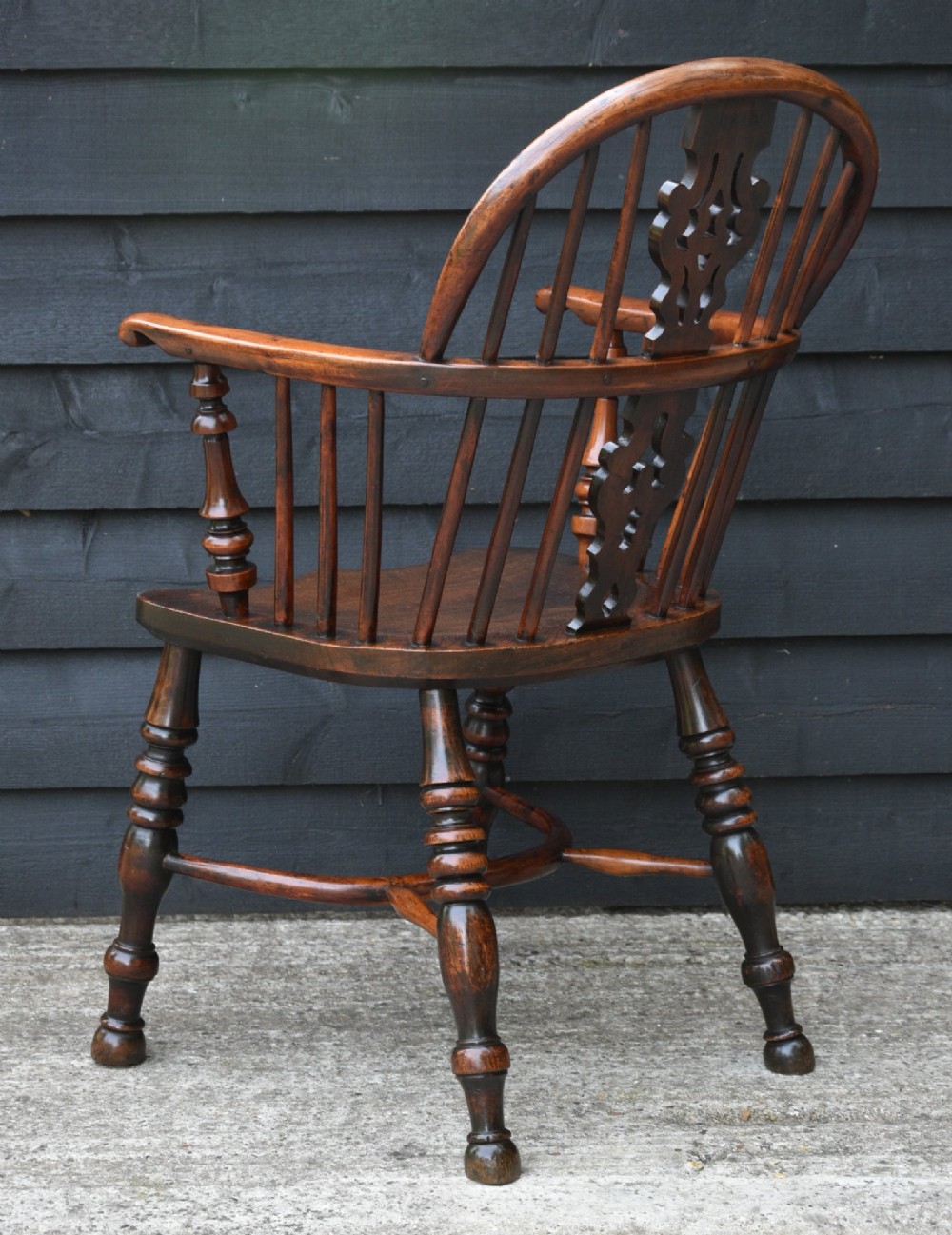 A matched pair of 18th-century Georgian yew and elm Windsor armchairs featuring curved hoop backs, pierced central splats, saddle seats, and turned legs. View VI