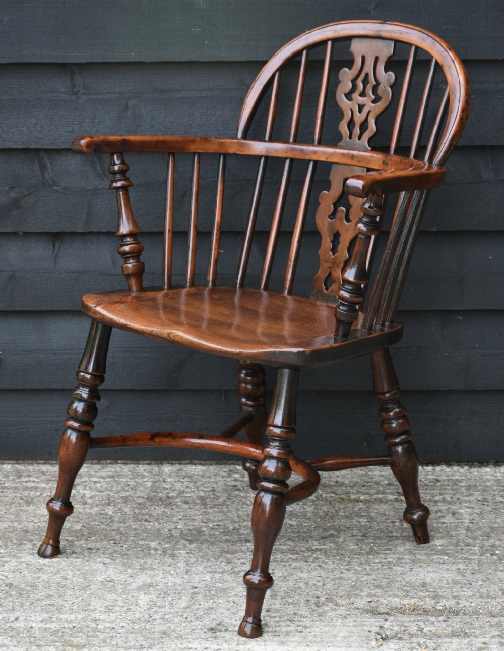 A matched pair of 18th-century Georgian yew and elm Windsor armchairs featuring curved hoop backs, pierced central splats, saddle seats, and turned legs. View IX