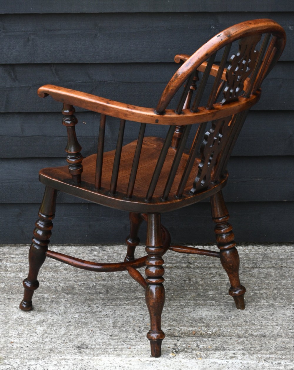 A matched pair of 18th-century Georgian yew and elm Windsor armchairs featuring curved hoop backs, pierced central splats, saddle seats, and turned legs. View XI
