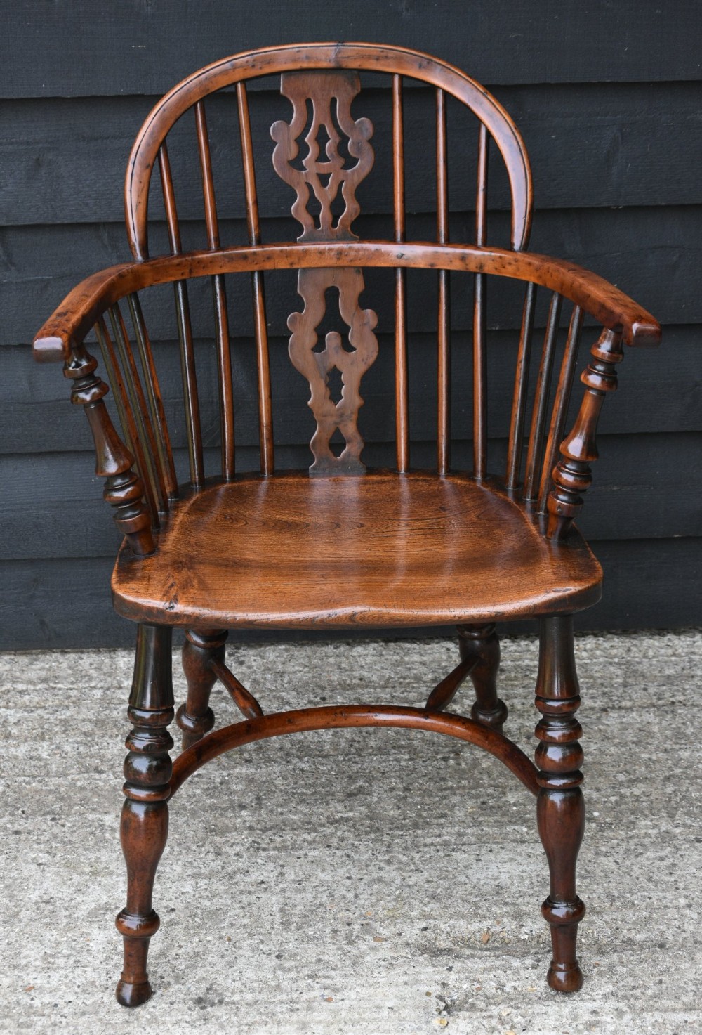A matched pair of 18th-century Georgian yew and elm Windsor armchairs featuring curved hoop backs, pierced central splats, saddle seats, and turned legs. View XII