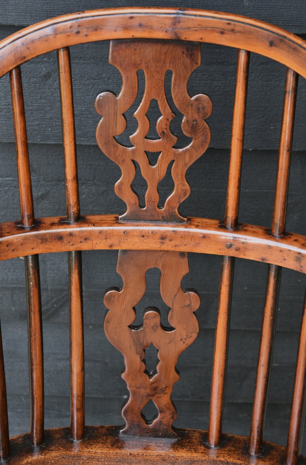 A matched pair of 18th-century Georgian yew and elm Windsor armchairs featuring curved hoop backs, pierced central splats, saddle seats, and turned legs. View XIII