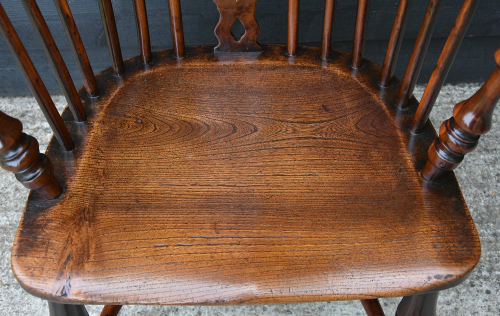 A matched pair of 18th-century Georgian yew and elm Windsor armchairs featuring curved hoop backs, pierced central splats, saddle seats, and turned legs. View XIV
