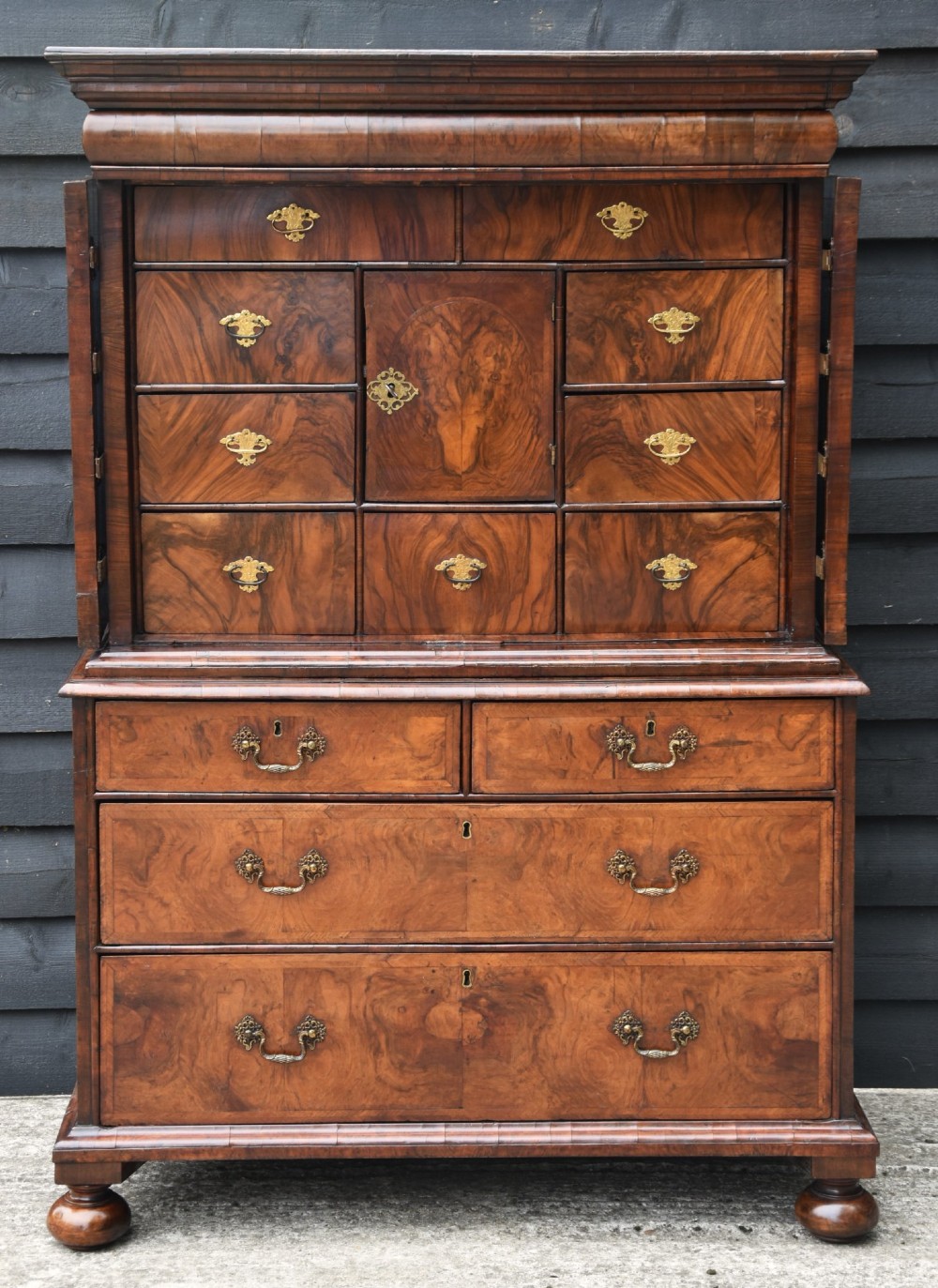 A seventeenth-century William and Mary walnut cabinet on chest featuring double doors with decorative brass hinges above three drawers on bun feet. View II