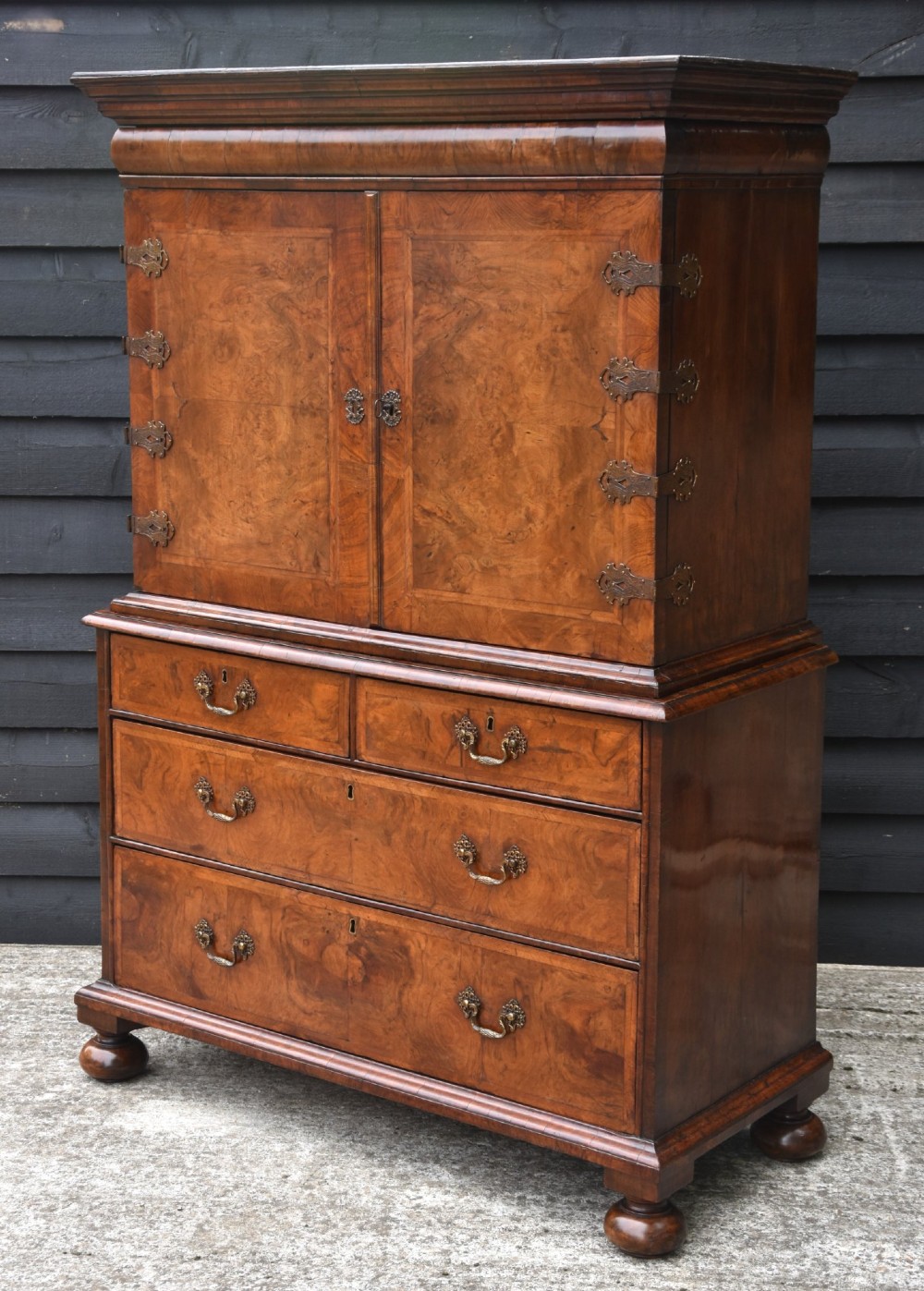 A seventeenth-century William and Mary walnut cabinet on chest featuring double doors with decorative brass hinges above three drawers on bun feet. View IV