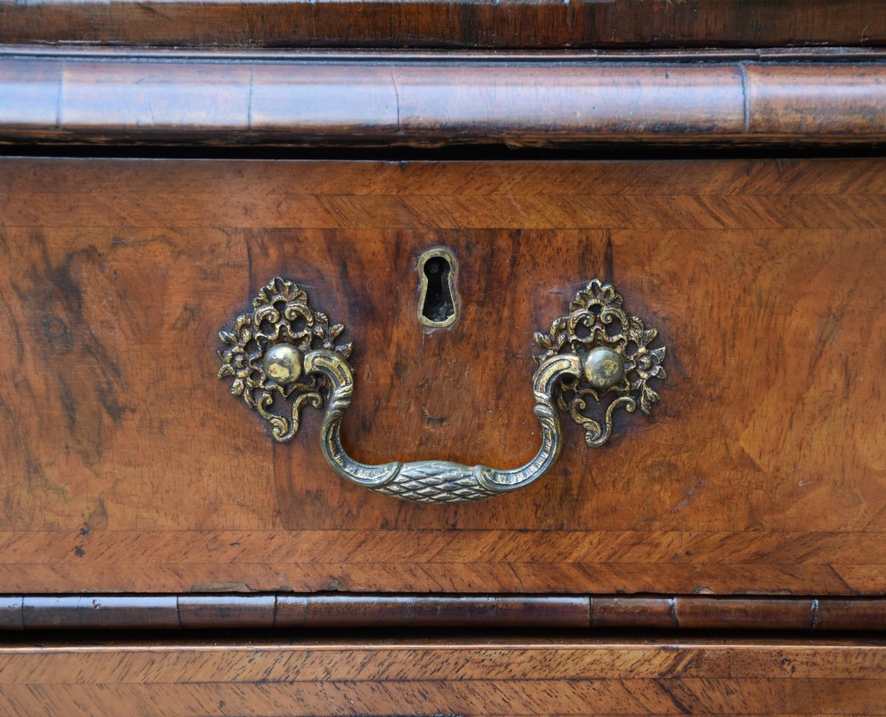 A seventeenth-century William and Mary walnut cabinet on chest featuring double doors with decorative brass hinges above three drawers on bun feet. View VII