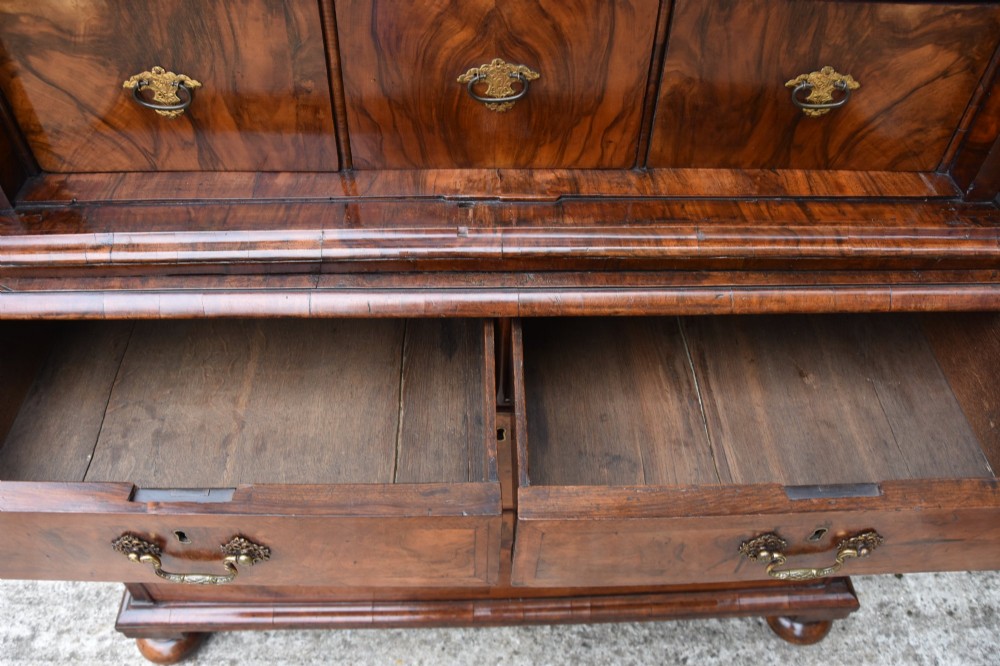 A seventeenth-century William and Mary walnut cabinet on chest featuring double doors with decorative brass hinges above three drawers on bun feet. View XI