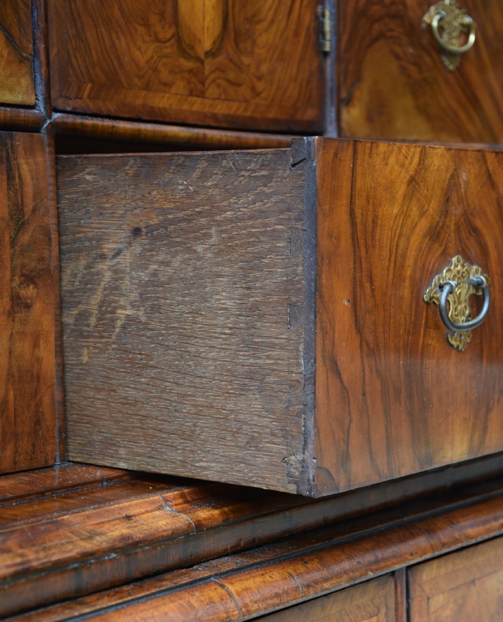 A seventeenth-century William and Mary walnut cabinet on chest featuring double doors with decorative brass hinges above three drawers on bun feet. View XII