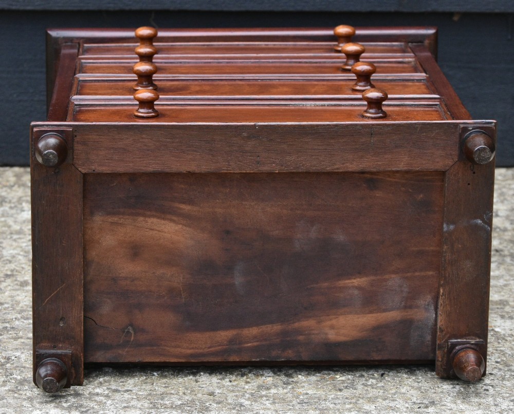 A Victorian mahogany miniature chest of drawers featuring four drawers with turned wooden knobs set upon short turned feet. View V