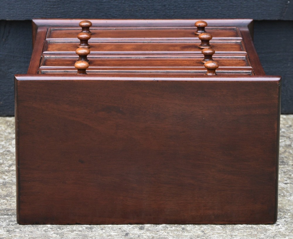 A Victorian mahogany miniature chest of drawers featuring four drawers with turned wooden knobs set upon short turned feet. View VII
