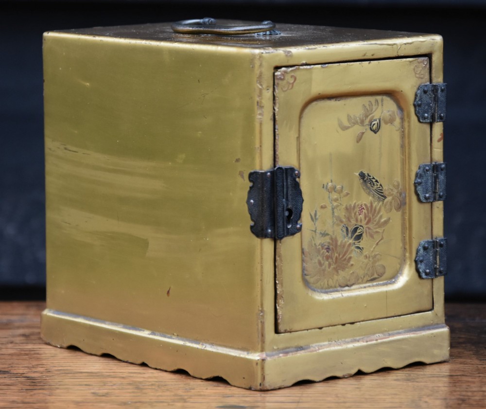 A small gold-lacquered Japanese cabinet featuring a single door with hand-painted bird and flower motifs and dark metal hinges. View II