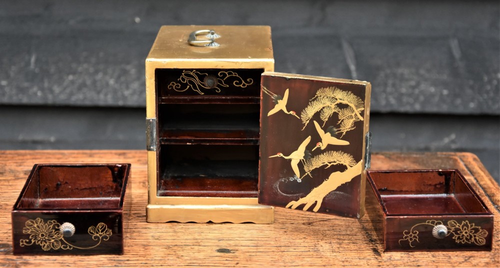 A small gold-lacquered Japanese cabinet featuring a single door with hand-painted bird and flower motifs and dark metal hinges. View IX