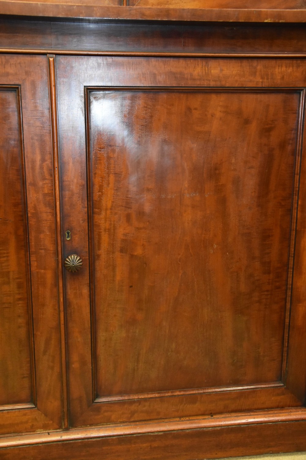 A large 19th-century William IV mahogany library bookcase cabinet featuring glazed upper doors above panelled lower cupboard doors. View VII