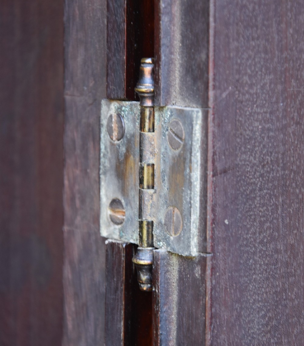 An 18th-century Georgian longcase clock in flame mahogany with an arched brass dial and brass finials. View VII