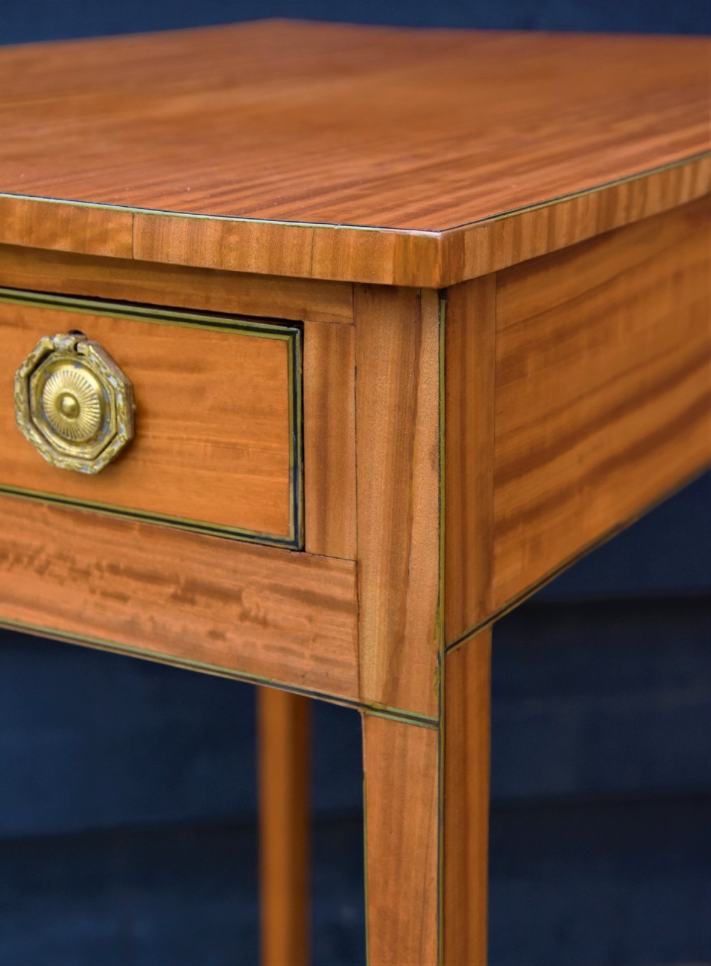 A Georgian satinwood lamp table featuring a single frieze drawer with brass handles and slender square tapered legs. View V
