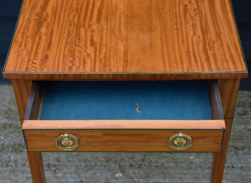 A Georgian satinwood lamp table featuring a single frieze drawer with brass handles and slender square tapered legs. View VIII