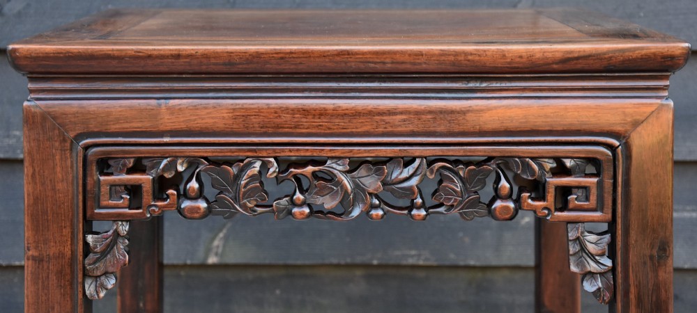 A 19th-century Chinese square rosewood low table featuring hand-carved aprons, a floating panel top, and straight legs terminating in scroll feet. View III