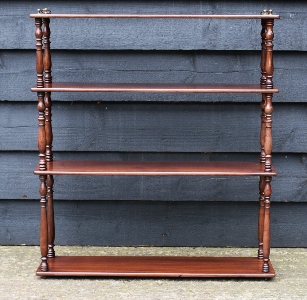 A four-tier mahogany hanging wall shelf unit featuring turned spindle supports and brass hanging rings at the top. View VI