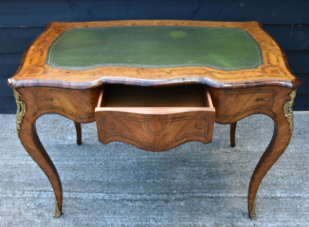 A 19th-century French kingwood writing desk featuring a green leather top, serpentine sides, marquetry inlay, and gilt bronze mounts. View II