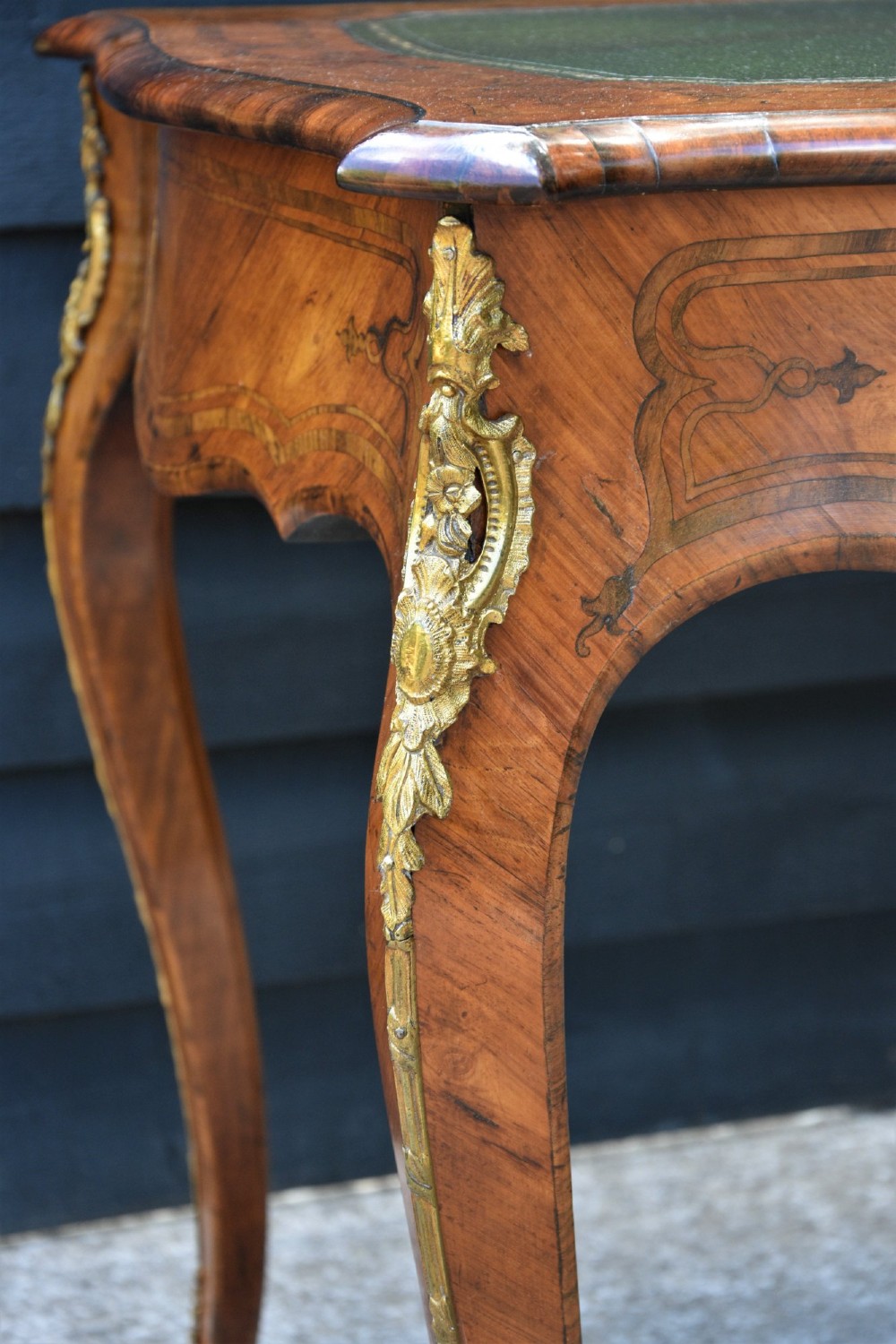 A 19th-century French kingwood writing desk featuring a green leather top, serpentine sides, marquetry inlay, and gilt bronze mounts. View III