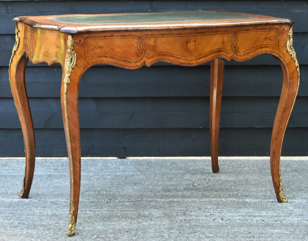 A 19th-century French kingwood writing desk featuring a green leather top, serpentine sides, marquetry inlay, and gilt bronze mounts. View VI