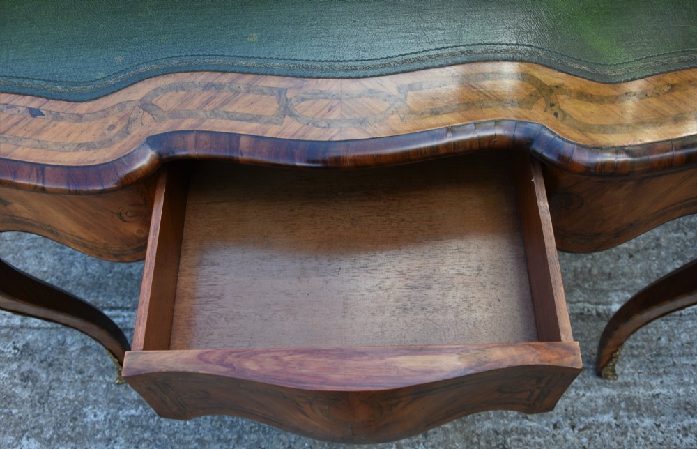 A 19th-century French kingwood writing desk featuring a green leather top, serpentine sides, marquetry inlay, and gilt bronze mounts. View VIII