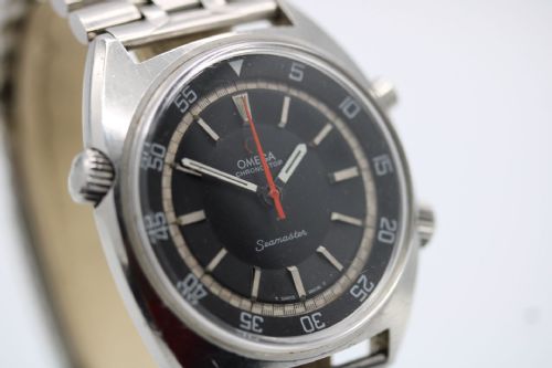 fig 3. A 1968 stainless steel Omega Seamaster Chronostop wristwatch with a black dial, inner rotating bezel, and central orange hand.