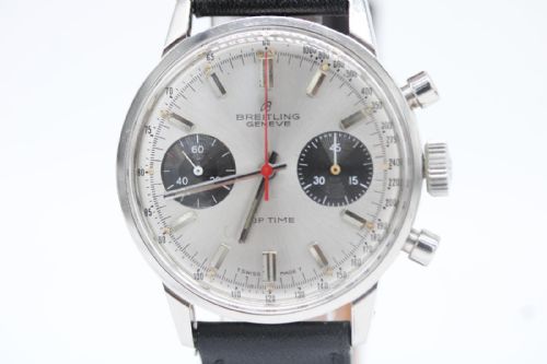 fig 1. A vintage 1969 Breitling Top Time wristwatch with a silver panda dial, two black sub-dials, a central red hand, and a black leather strap.