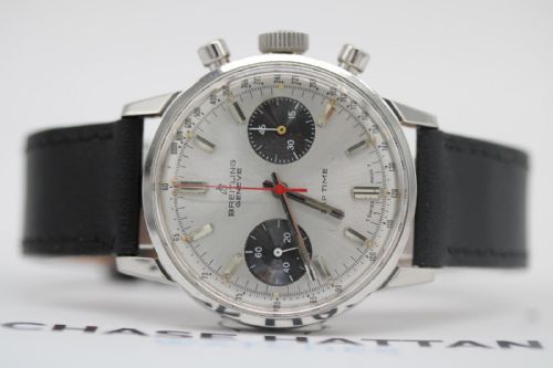 fig 5. A vintage 1969 Breitling Top Time wristwatch with a silver panda dial, two black sub-dials, a central red hand, and a black leather strap.