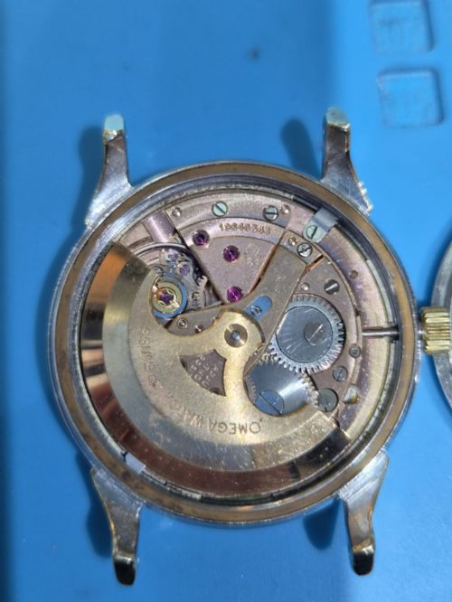 fig 2. A 1962 vintage Omega Constellation wristwatch featuring a gold pie-pan dial, date aperture, and brown leather strap.