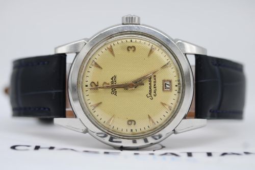 fig 8. A vintage 1952 Omega Seamaster Calendar wristwatch featuring a stainless steel case, textured gold-coloured dial with date display at six oclock, and a black leather strap.