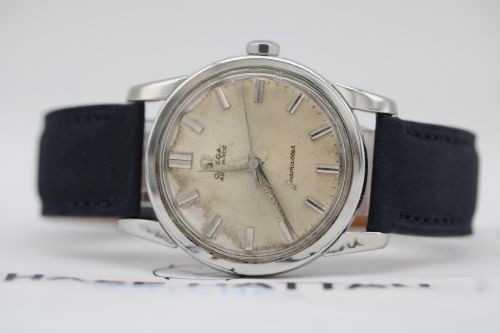 fig 5. A 1950s stainless steel Omega Seamaster wristwatch featuring a patinated cream dial with silver baton indices and a black leather strap.