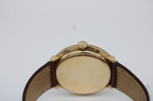 fig 8. A vintage circular 9ct gold wristwatch by Longines featuring a silver dial with gold baton hour markers and a brown leather strap.