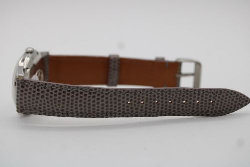 fig 7. A vintage 1960 Omega Seamaster automatic wristwatch with a stainless steel case, silver cream dial, and grey textured leather strap.