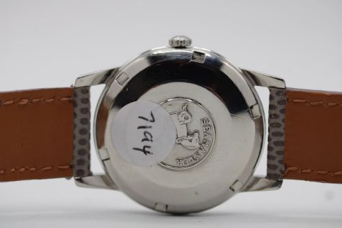 fig 8. A vintage 1960 Omega Seamaster automatic wristwatch with a stainless steel case, silver cream dial, and grey textured leather strap.