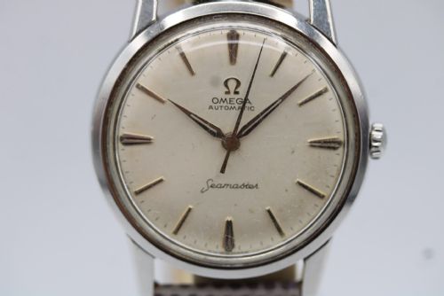 fig 9. A vintage 1960 Omega Seamaster automatic wristwatch with a stainless steel case, silver cream dial, and grey textured leather strap.